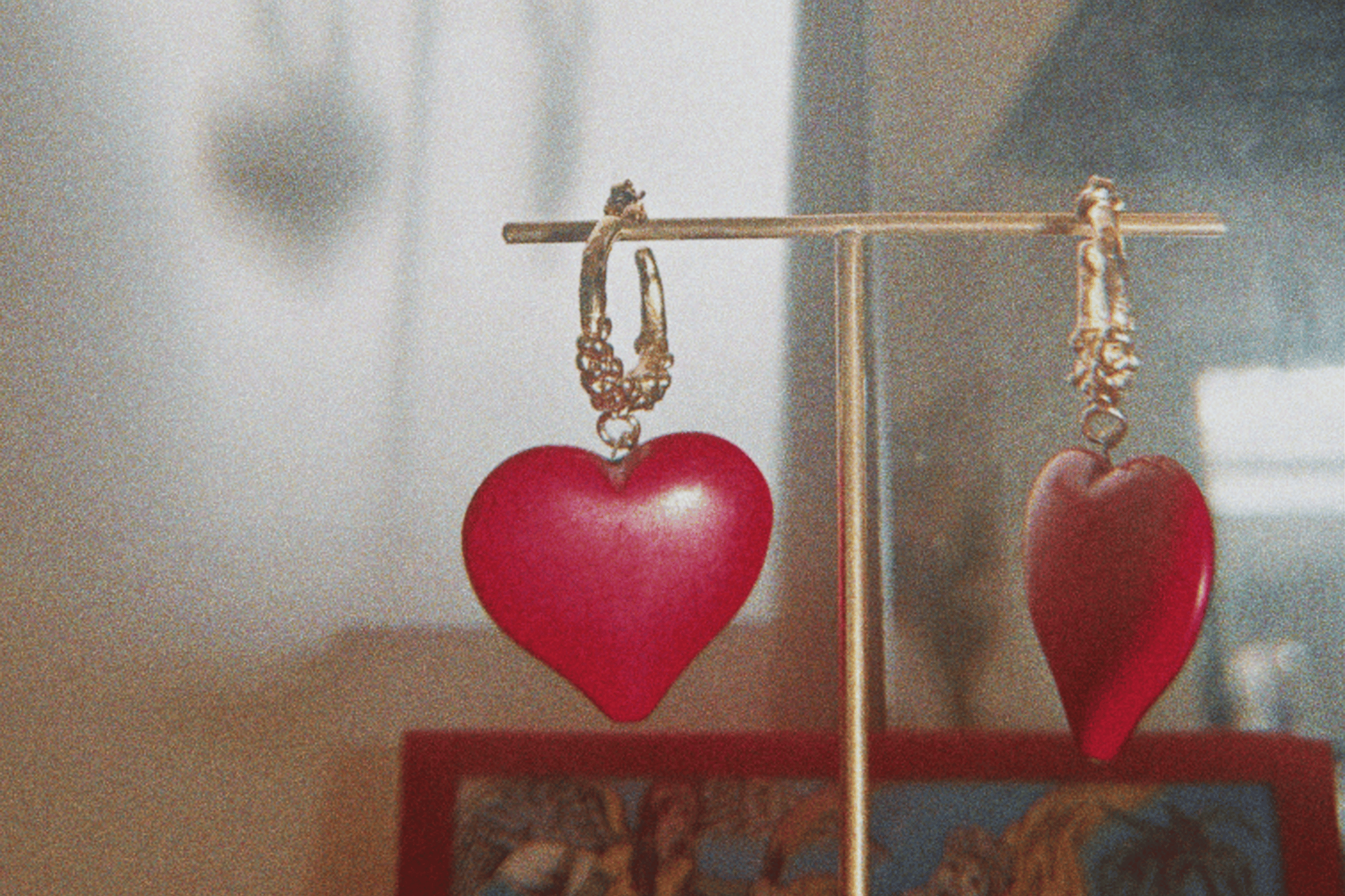 créoles en bronze plaqué or faites de multiples granulations irrégulières, ornées d'une graine en forme de coeur rouge écarlate, collection Esther de Carthage, fabrication artisanale française